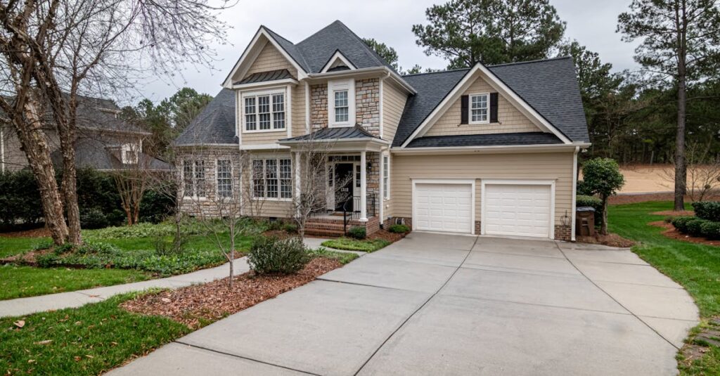 Mortgage Refinance & Payoff Strategies Charming suburban home featuring a two-car garage, manicured lawn, and inviting entrance.